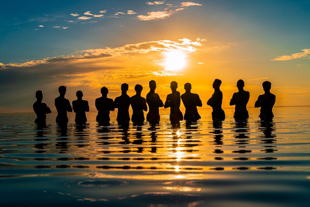 A group of silhouettes standing in water during sunset at Great Salt Lake, Utah.